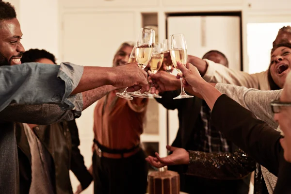 Foto mostra alegre brinda com taças de champanhe durante uma festa de aniversário em casa. Ressaca, álcool