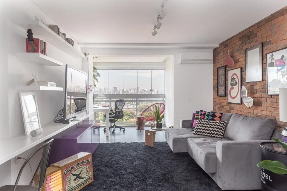 A parede de tijolinhos e o piso de cimento são dois dos revestimentos usados no apartamento A parede de tijolinhos e o piso de cimento são dois dos revestimentos usados no apartamento
