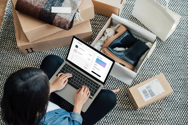 Foto colorida de pessoa fazendo compras em um laptop