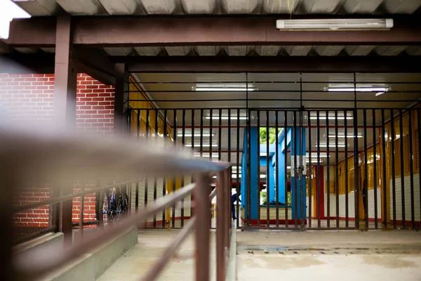 Fotografia colorida de portão de escola trancado