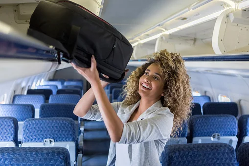 mulher colocando mala de mão em avião