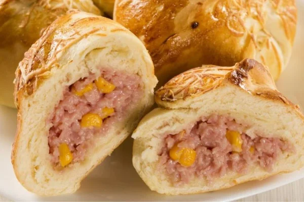 enroladinho de queijo e presunto com milho em um prato