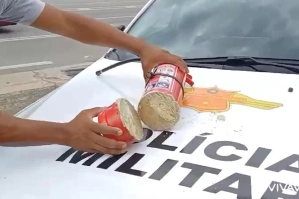 Imagem colorida de um extintor de incêndio recheado com base de cocaína aberto em cima de uma viatura da Polícia Militar - Metrópoles