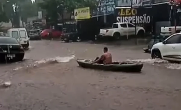 Imagem colorida de homem em barco durante alagamento - Metrópoles