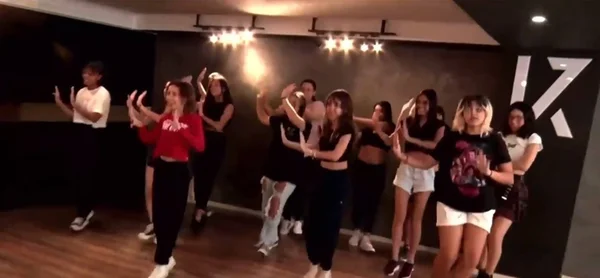 Imagem colorida de pessoas dançando K-pop - Metrópoles