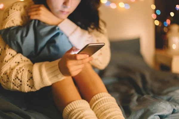 Imagem colorida de adolescente segurando o celular - Metrópoles