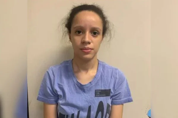 foto colorida de mulher de blusa asul e cabelo preso