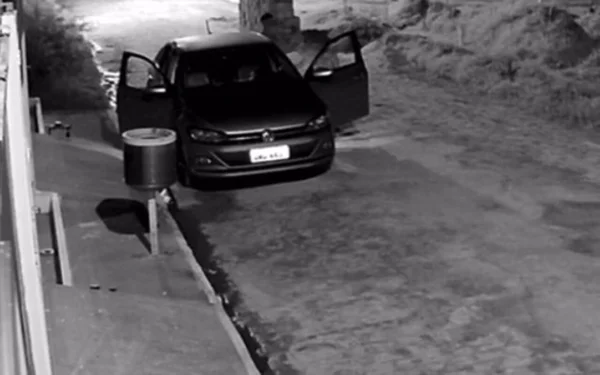 Imagem em preto e branco do momento em que os criminosos efetuam os disparos