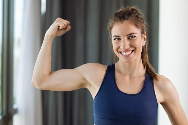 Foto colorida de mulher mostrando o braço musculoso - Metrópoles