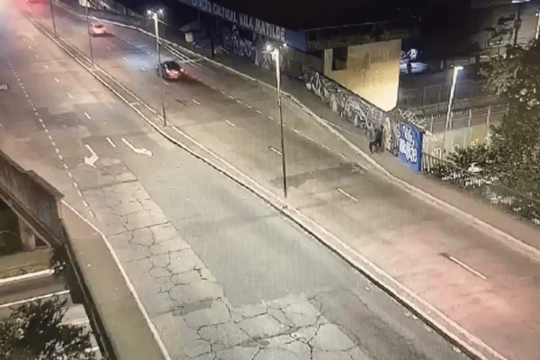 Imagem colorida de casal caminhando em calçada antes de ser atingido por carro - Metrópoles