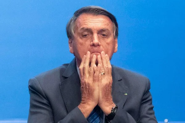 O presidente Bolsonaro (PL) em evento no Planalto. Ela leva as mãos ao queixo e tem expressão preocupada - Metrópoles