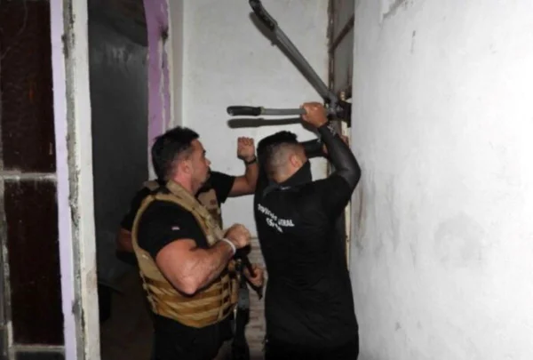 foto colorida de agentes tentando invadir quarto de hotel