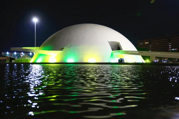 Imagem coloridade Monumento em Brasília iluminado em verde e amarelo - Metrópoles