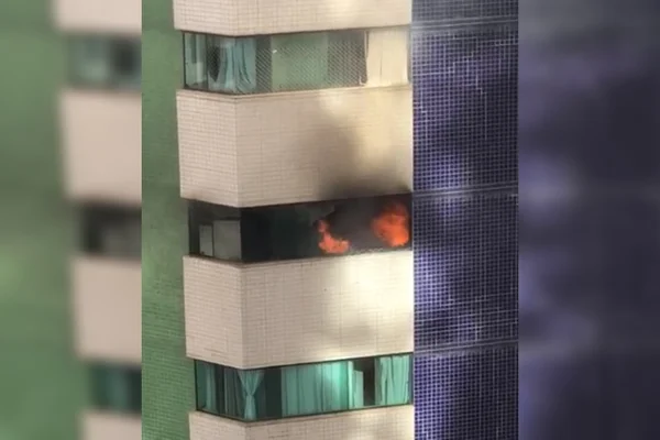 Fogo e fumaça em apartamento de prédio branco com verde e azul