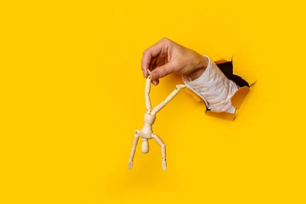 boneco sendo manipulado por mão humana