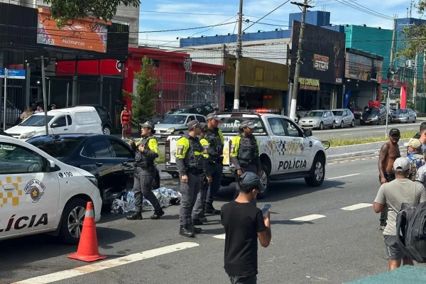 Imagem colorida de corpo de motociclista no chão. Metrópoles