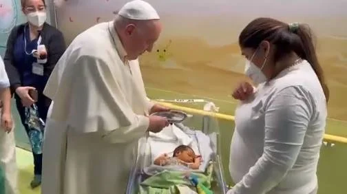 imagem colorida do papa Francisco batizando criança em hospital de Roma - Metrópoles