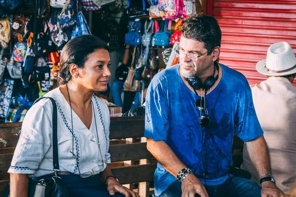 dira paes de camisa e bolsa pendurada conversa com diretor de filme de camiseta azul - metrópoles