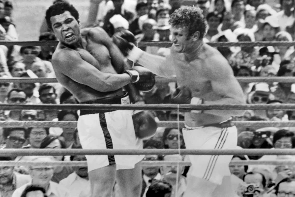 O boxeador americano Muhammad Ali (1942 - 2016) e o boxeador britânico Joe Bugner em ação durante a luta pelo título mundial dos pesos pesados em Kuala Lumpur, Malásia, em 1º de julho de 1975. A foto foi tirada no 14º round da luta de 15 rounds.