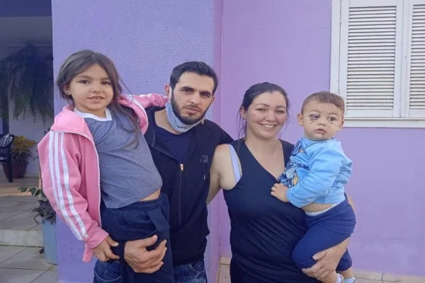 Família tira foto em frente de casa