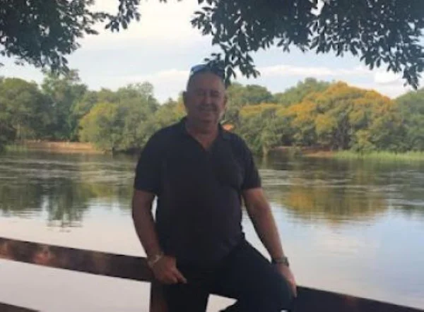 Patrão na Bahia obriga funcionárias a votar em Bolsonaro. Na foto, o homem sorri para a câmera, diante de um lago com várias árvores - Metrópoles