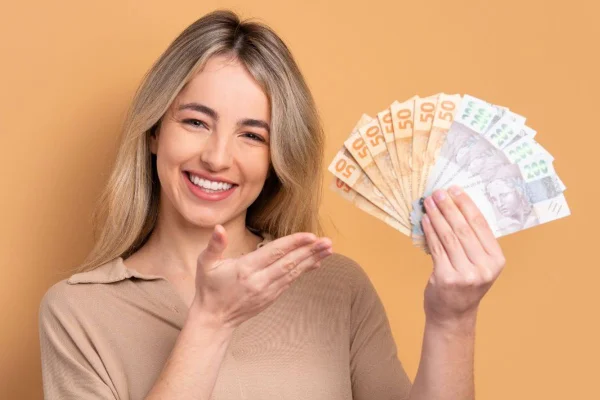 Mulher segurando notas de cem e cinquenta reais