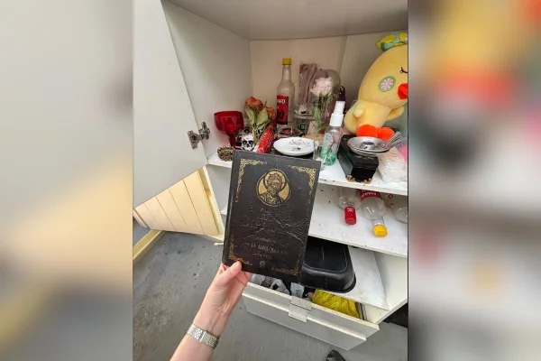 Foto colorida mostra livro com conteúdo ritualístico apreendido pela polícia. Objeto estava em altar escondido.