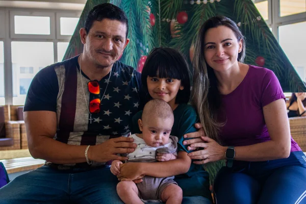Foto mostra o neném Miguel, que fez um transplante de medula óssea, com os pais e o irmão - Metrópoles