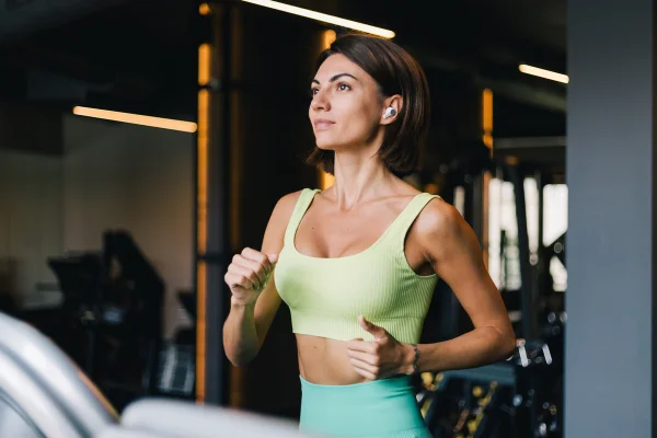Mulher em treino na academia, correndo na esteira- Metrópoles