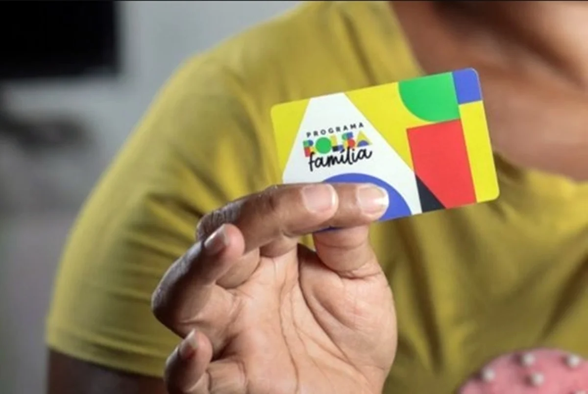 Mão segurando um cartão do Bolsa Família Mão segurando um cartão do Bolsa Família