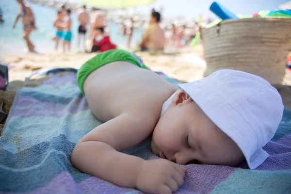 Imagem colorida mostra bebê dormindo na praia - Metrópoles