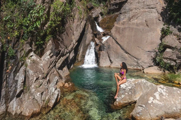 Foto colorida de uma mulher na cachoeira - Metrópoles