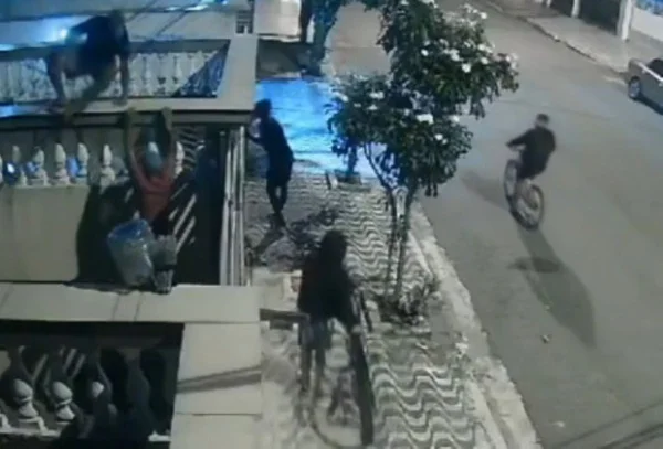 Imagem de adolescentes em porta de condomínio; dois escalam e outros dois chegam de bicicleta - Metrópoles