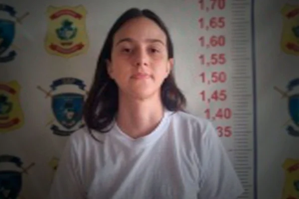 Foto colorida de mulher de cabelo comprido em penitenciária