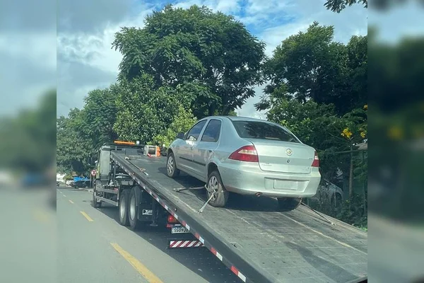 Carro prata em cima de guincho