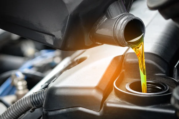 Fotografia colorida mostrando óleo sendo colocado em motor-Metrópoles