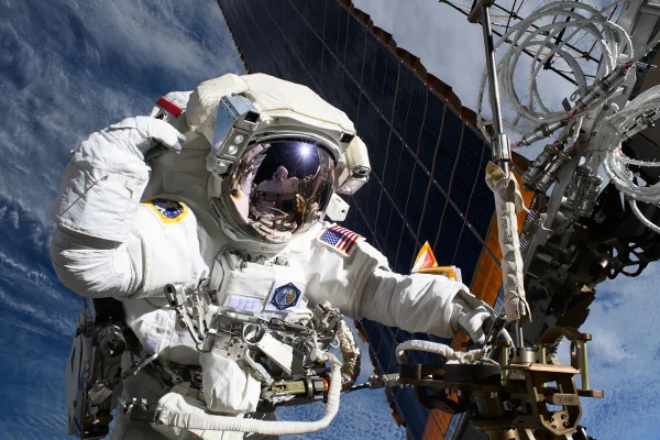 Foto mostra a astronauta da NASA e engenheira de voo da Expedição 72, Anne McClain, é fotografada perto de um dos principais painéis solares da Estação Espacial Internacional durante uma caminhada espacial para modernizar o sistema de geração de energia da estação orbital e realocar uma antena de comunicações.