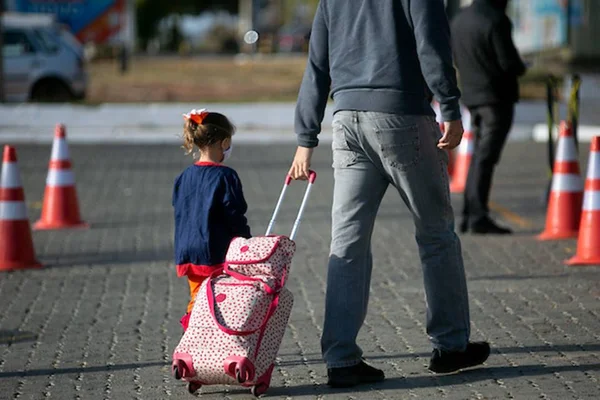 Aluna indo para a escola com o responsável