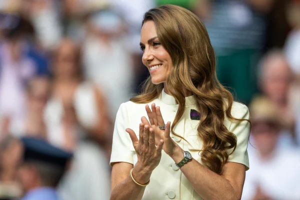 Foto colorida de mulher batendo palmas. Ela está com o cabelo ondulado jogado no ombro - Metrópoles