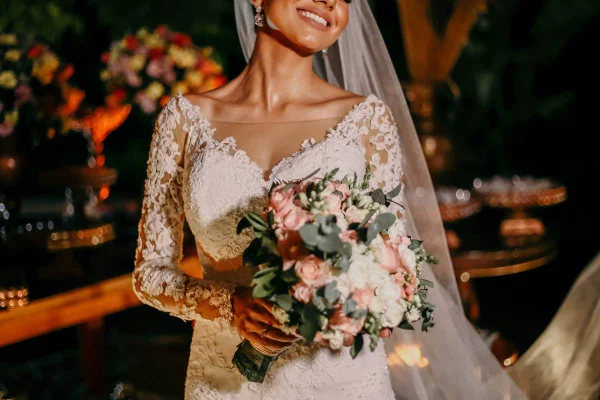Foto de mulher vestida de novia sorrindo com buque na mao