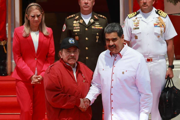 Imagem colorida mostra Daniel Ortega e Nicolás Maduro apertando as mãos - Metrópoles