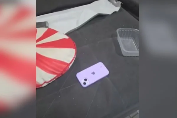 Foto colorida mostra celular da vítima dentro da casa de casal suspeito de participar de homicídio.