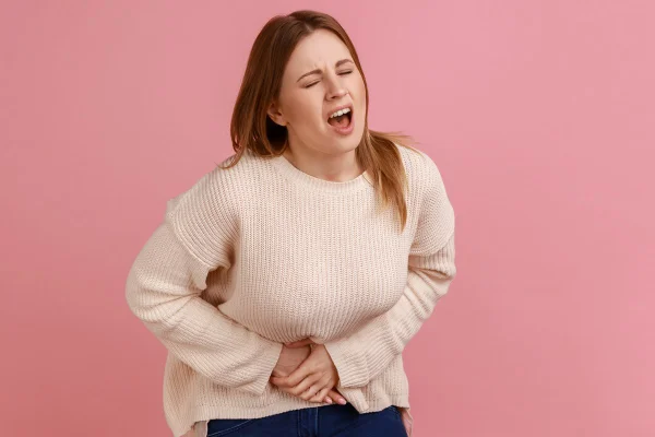 Foto colorida de mulher com as mãos na barriga - Metrópoles