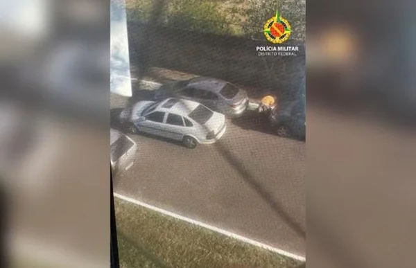Imagem mostra dois carros, um branco e um prata, estacionados lado a lado em uma rua
