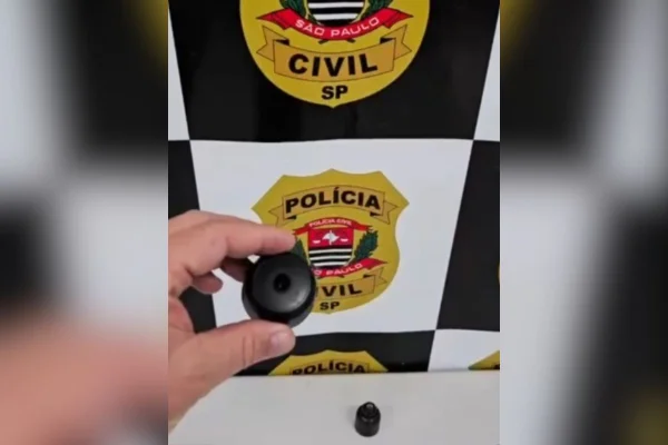 Foto colorida de reprodução de vídeo mostrando delegado expondo tamanho de câmeras ocultas instaladas por homem para gravar enteada em situações íntimas, em Cerquilho, interior de São Paulo.