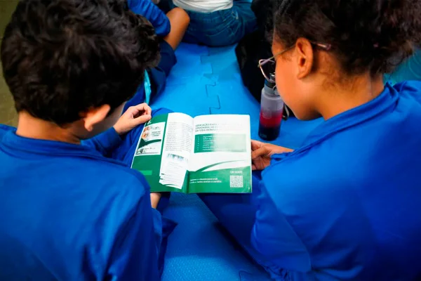 Crianças lendo cartilha