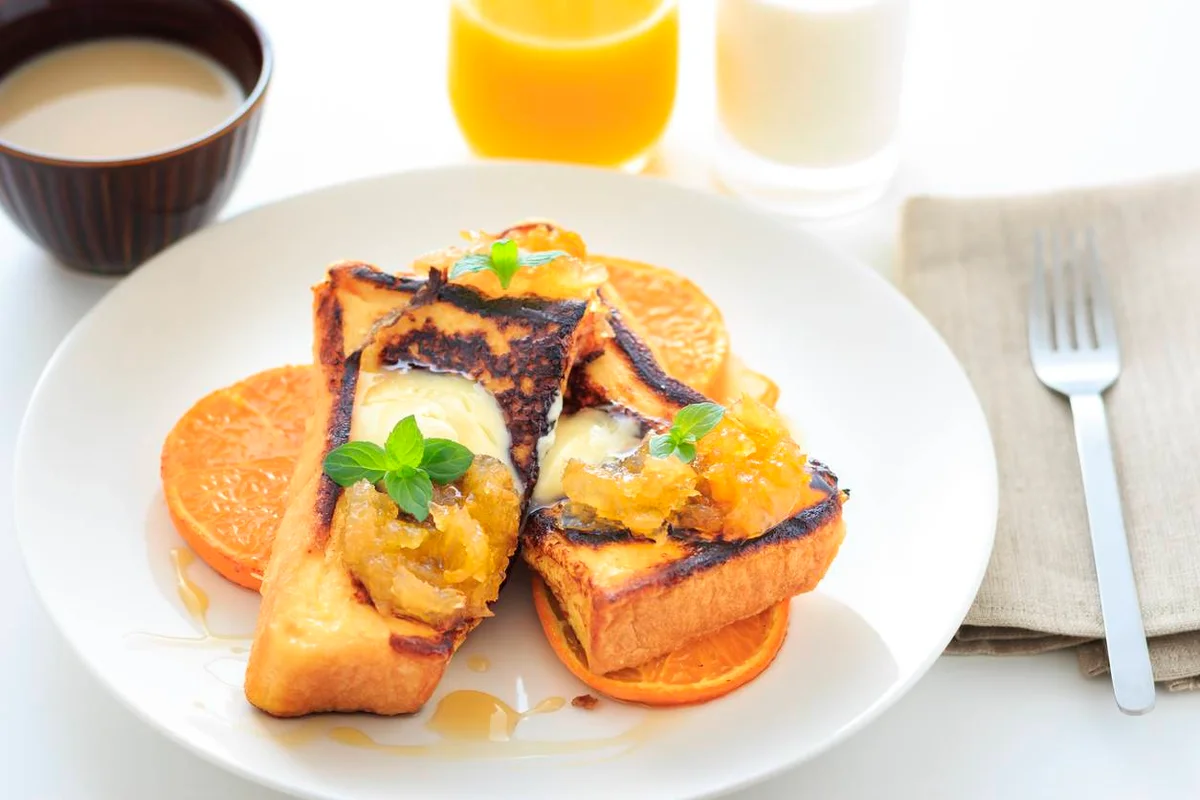 Rabanadas de laranja - use dois pães franceses; um ovo; raspas de uma laranja; 1/4 de xícara de leite; canela em pó; uma colher de sopa de manteiga. Para o molho, faça uma calda com 3 colheres de sopa de geleia de laranja; suco de uma laranja e 1/2 colher de sopa de açúcar. Para o preparo corte os pães em fatias de cerca de 2 cm, na diagonal e descartando as pontas. Em um recipiente largo, misture o ovo, o leite, as raspas de laranja e a canela em pó. Passe as fatias de pão na mistura de ovo, virando algumas vezes de um lado e do outro. É preciso que o pão fique úmido, mas não pode ficar mole a ponto de quebrar. Aperte levemente a fatia para retirar o excesso de líquido. Aqueça a manteiga em uma frigideira e coloque as fatias para fritar durante cerca de um minuto de cada lado. Polvilhe açúcar com canela por cima. Para a calda: leve todos os ingredientes ao fogo, em uma panelinha, e deixe ferver (fogo baixo) e reduzir um pouco enquanto você prepara as fatias. Sirva o molho quente ou frio por cima das rabanadas. Rende 3 porções Rabanadas de laranja - use dois pães franceses; um ovo; raspas de uma laranja; 1/4 de xícara de leite; canela em pó; uma colher de sopa de manteiga. Para o molho, faça uma calda com 3 colheres de sopa de geleia de laranja; suco de uma laranja e 1/2 colher de sopa de açúcar. Para o preparo corte os pães em fatias de cerca de 2 cm, na diagonal e descartando as pontas. Em um recipiente largo, misture o ovo, o leite, as raspas de laranja e a canela em pó. Passe as fatias de pão na mistura de ovo, virando algumas vezes de um lado e do outro. É preciso que o pão fique úmido, mas não pode ficar mole a ponto de quebrar. Aperte levemente a fatia para retirar o excesso de líquido. Aqueça a manteiga em uma frigideira e coloque as fatias para fritar durante cerca de um minuto de cada lado. Polvilhe açúcar com canela por cima. Para a calda: leve todos os ingredientes ao fogo, em uma panelinha, e deixe ferver (fogo baixo) e reduzir um pouco enquanto você prepara as fatias. Sirva o molho quente ou frio por cima das rabanadas. Rende 3 porções