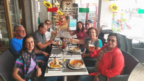 Fotografia colorida mostrando oito pessoas almoçando juntas-Metrópoles