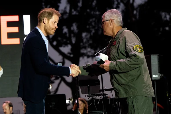 Prince Harry, Duke of Sussex (L) presents an award to Santa Barbara County Air Support Pilot Loren Courtney during the One805Live Fall Concert