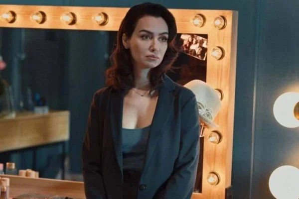 foto colorida de mulher de blazer azul com espelho ao fundo - metrópoles
